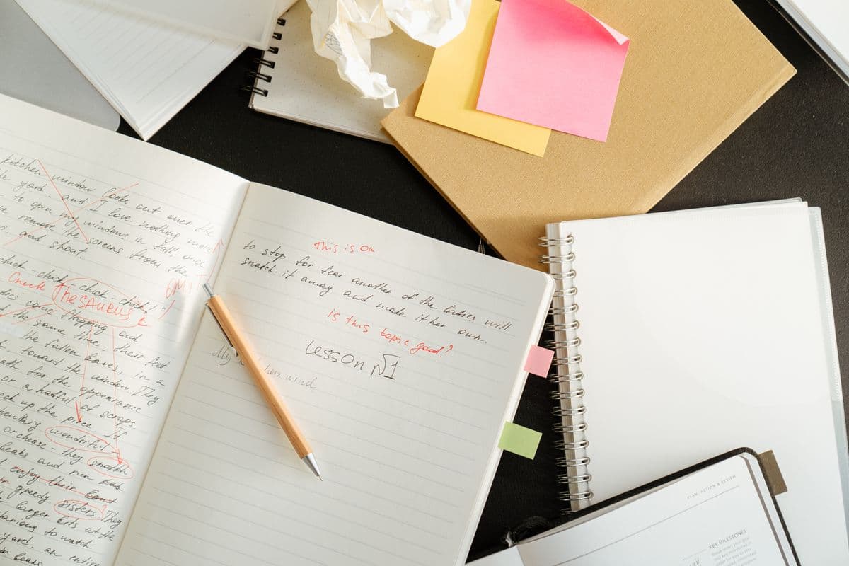 Blog content ideas for Malaysian SMEs — planning article topics in a notebook beside a laptop